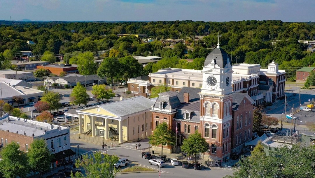Drone view of downtown Covington: the Newton County courthouse and the storefronts around the square.