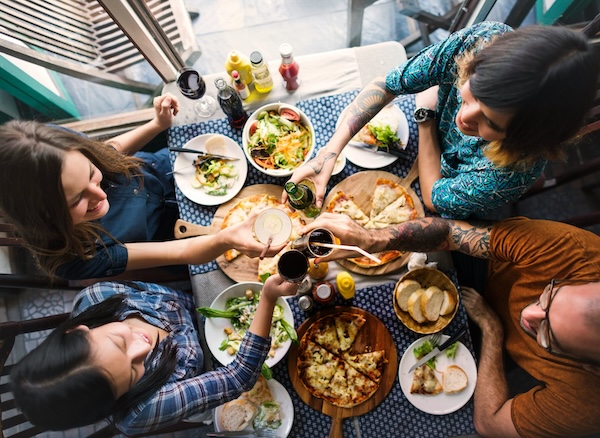 four people eating pizza